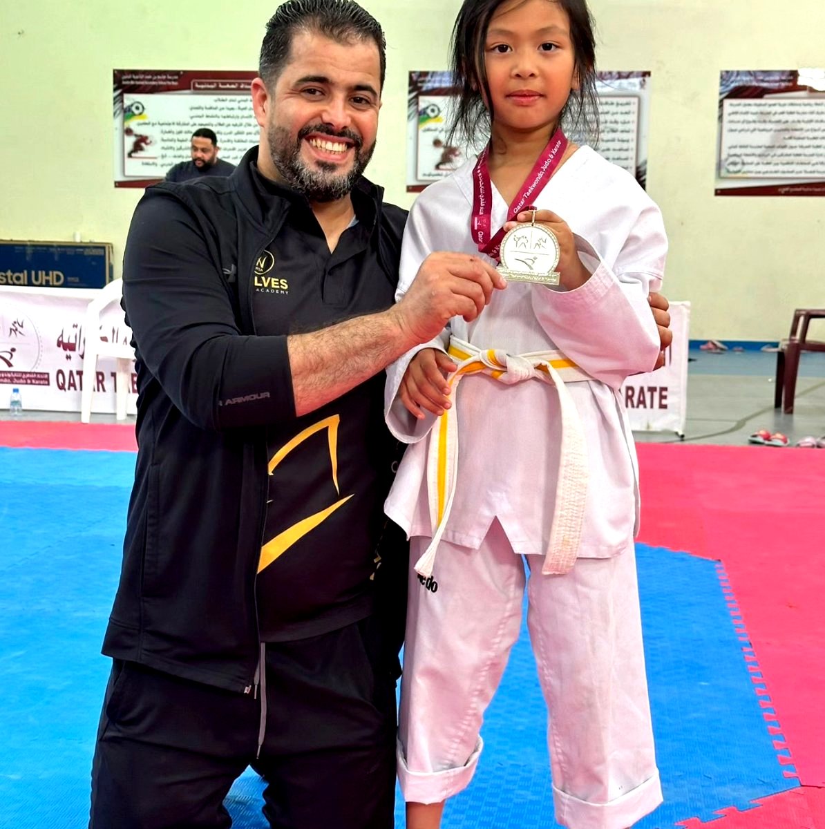 Coach with young student receiving medal