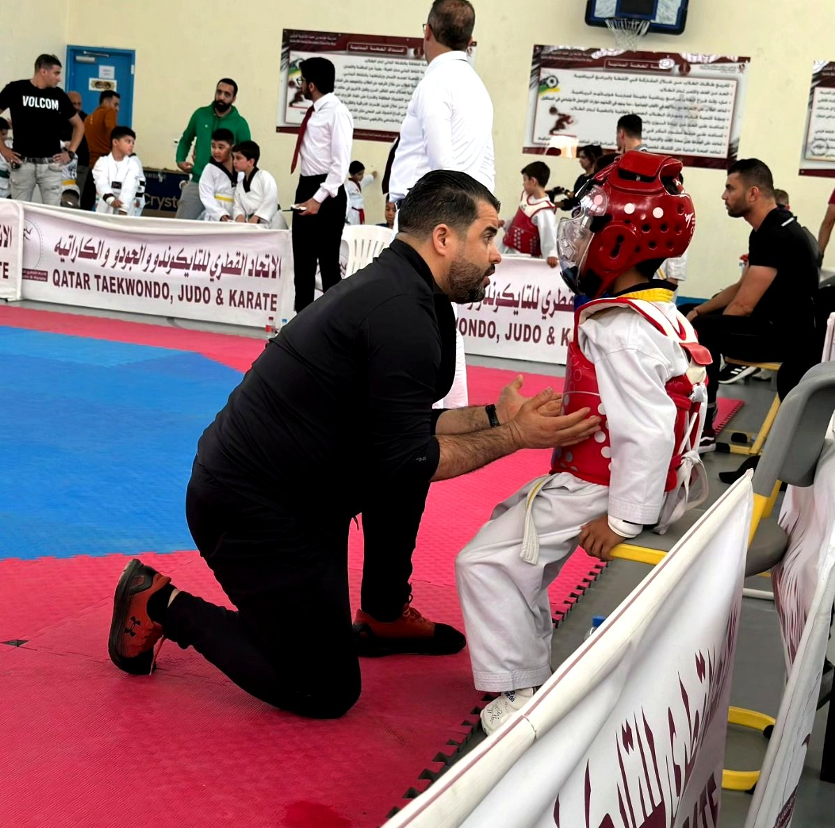 Coach giving instructions to young taekwondo athlete