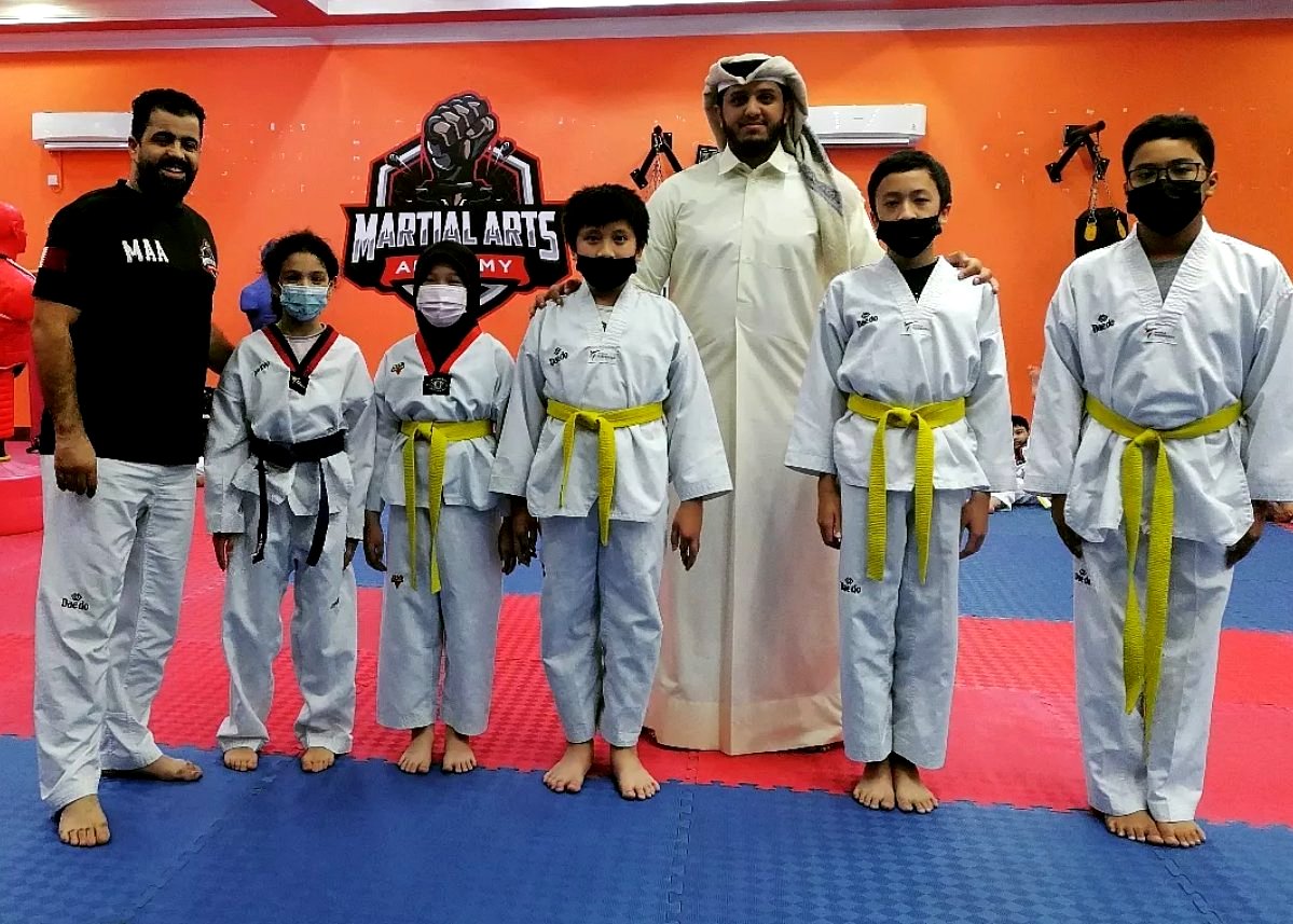 Coach with students in martial arts academy